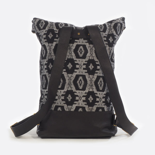 Back view of black and white dhaka fabric backpack with leather