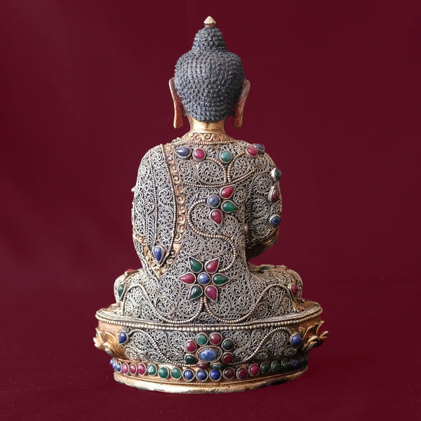 Amitabha Buddha Statue made of copper, lost wax casting, silver and gold plated, set with filigree and set synthetic gemstones in ruby red, emerald green, lapis lazuli blue. The face is set in gold. Handmade by Dragon Craft, Nepal