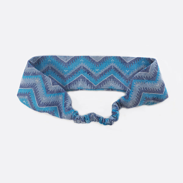 Back view of the light blue Battiayo headband. The scrunchy part, which gives the headband the elasticity is shown. The elastic part is covered with the dhaka fabric. 