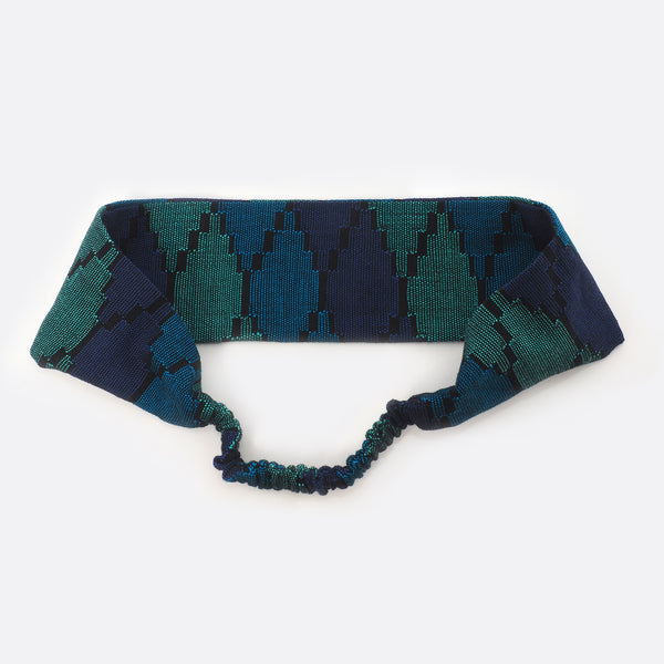 Back view of the dark blue Battiayo headband. The small scrunchy part, which gives the headband the elasticity is shown. The elastic part is covered with the dhaka fabric.