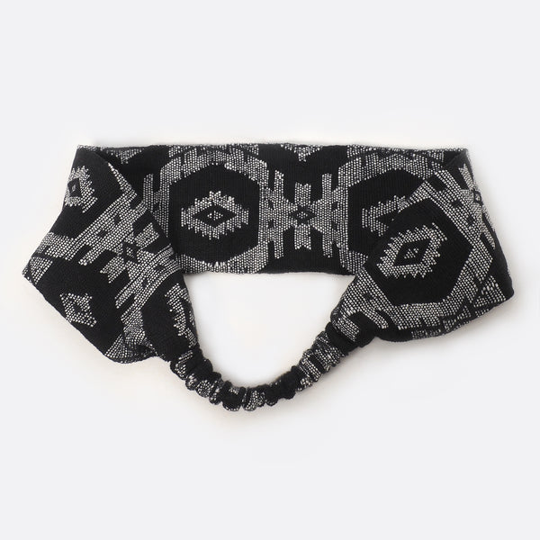 Back view of the Black & White Battiayo headband. The small scrunchy part, which gives the headband the elasticity is shown. The elastic part is covered with the dhaka fabric.