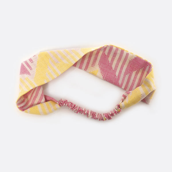 Headband is half turned around to show that each side is a bit different. On one side the dominant color is yellow. On the other side the dominant color is pink.