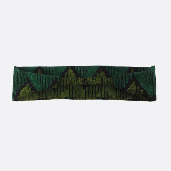 Back view of the Forest Green Battiayo headband. The small scrunchy part, which gives the headband the elasticity is shown. The elastic part is covered with the dhaka fabric.