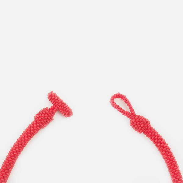 Close up of the necklace clasp. The clasp is open. The small glass beads are shown.