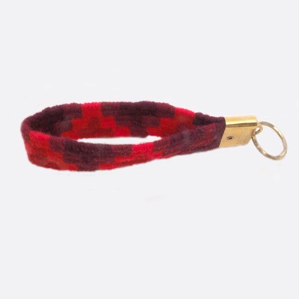 handwoven key chain with handmade brass buckle; key chain has 4 shades of red