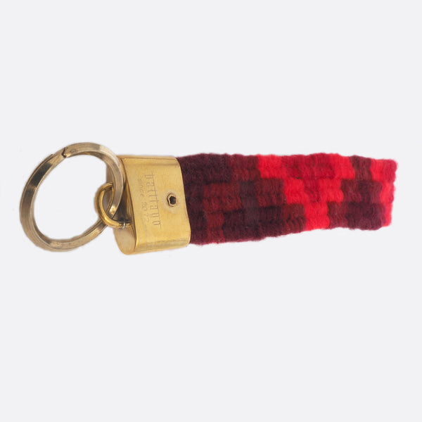 handwoven key chain with handmade brass buckle; key chain has 4 shades of red