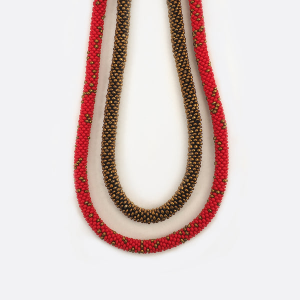 Close up of the handmade Battiayo necklace. The golden string is a bit shorter than the other string.