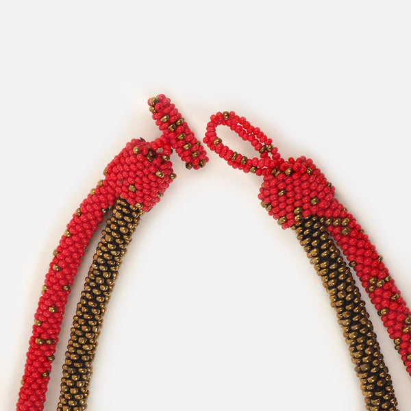 Close up of the necklace clasp. The clasp is open. The small glass beads are shown.