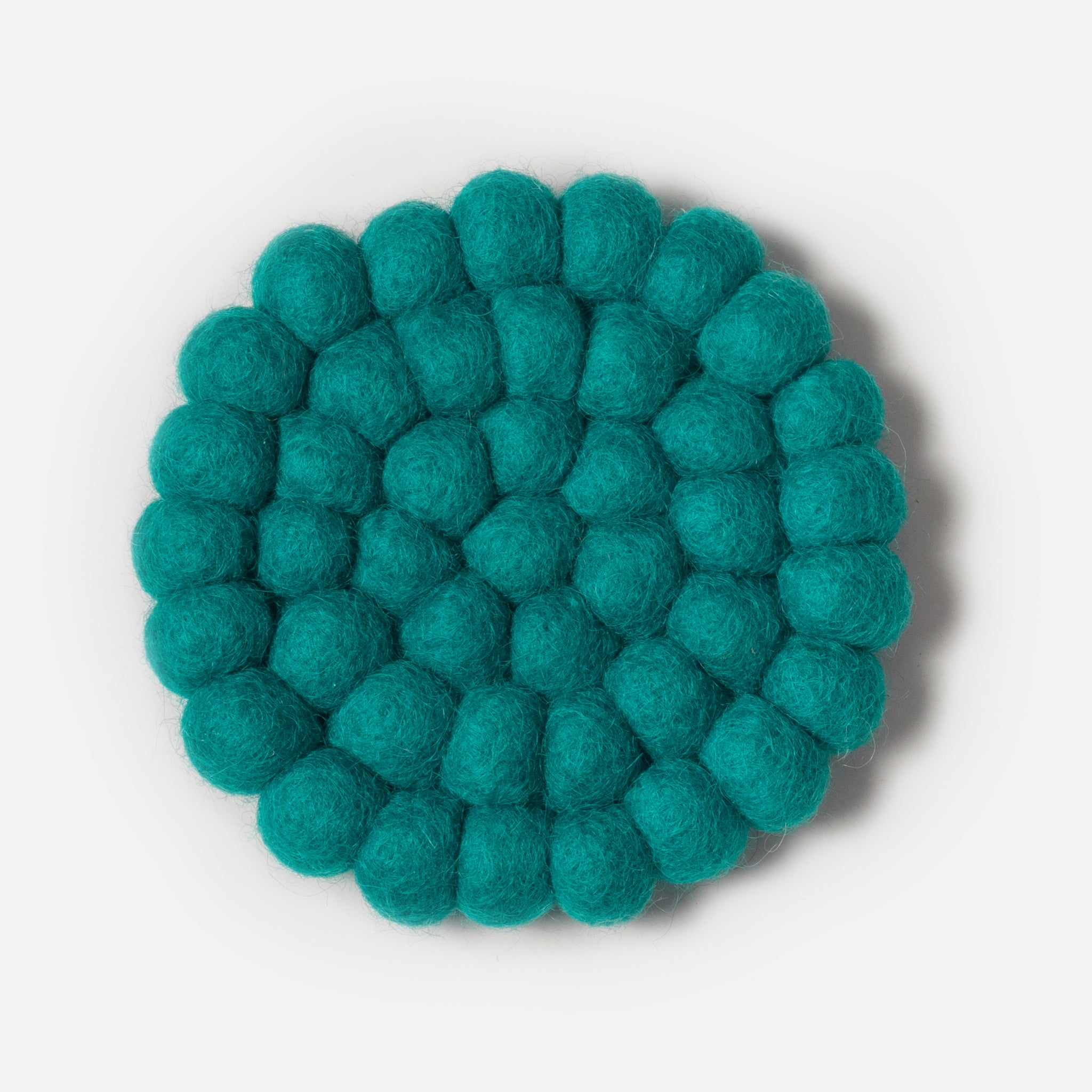 Round small felt coaster which is made from little felt balls. The color is turquoise.