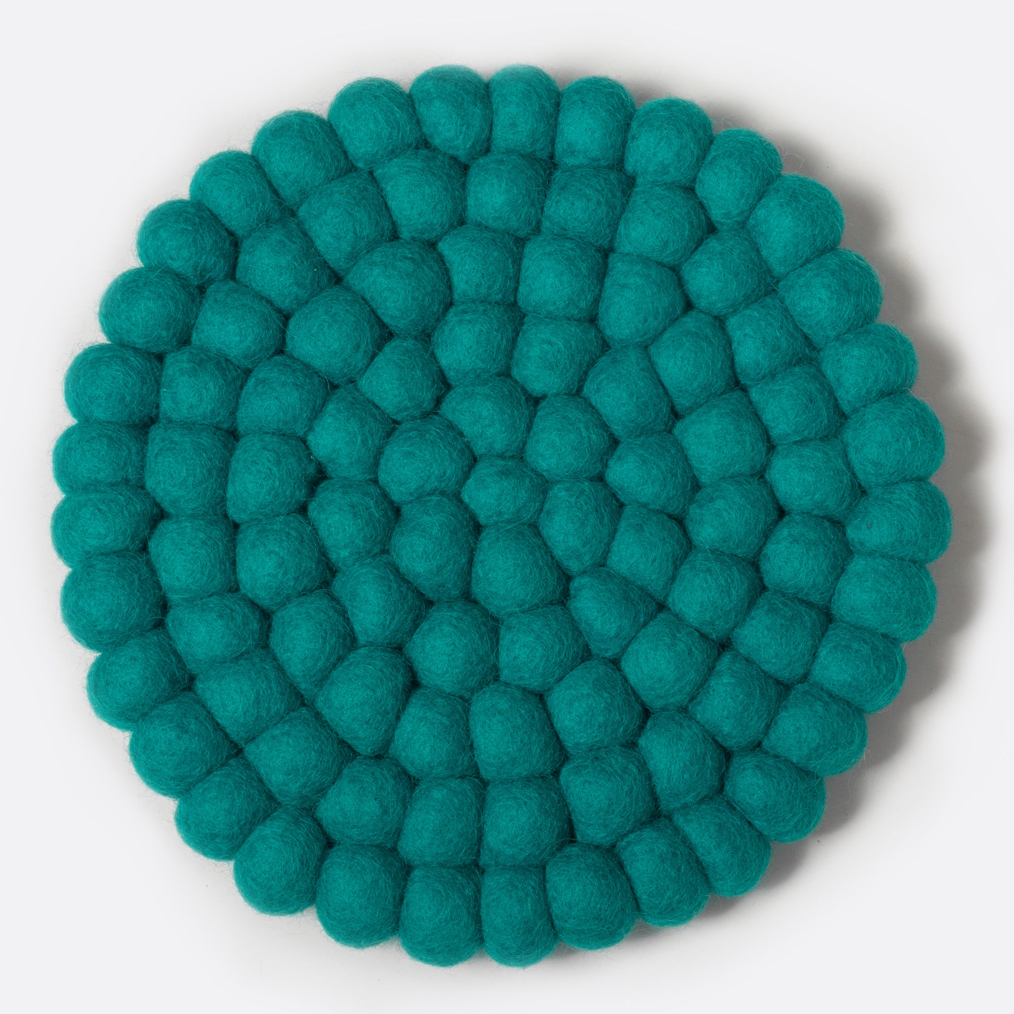Round felt coaster which is made from little felt balls. The color is turquoise.