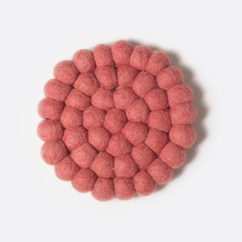 Round small felt coaster which is made from little felt balls. The color is rose.
