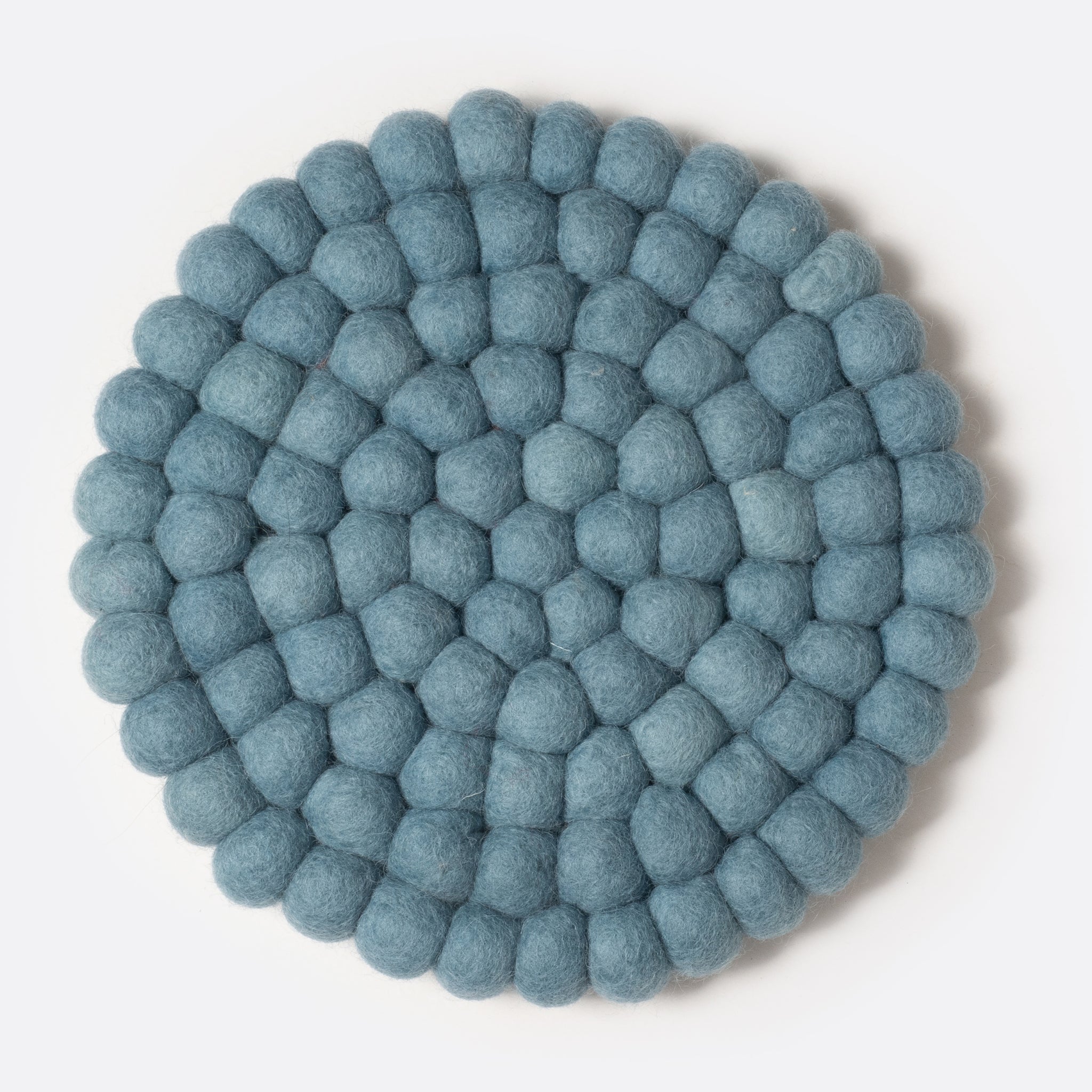 Round felt coaster which is made from little felt balls. The color is light blue-grey