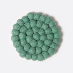 Round small felt coaster which is made from little felt balls. The color is pale green