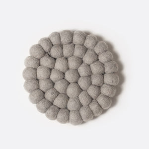Round felt coaster which is made from little felt balls. The color is yellow mustard.