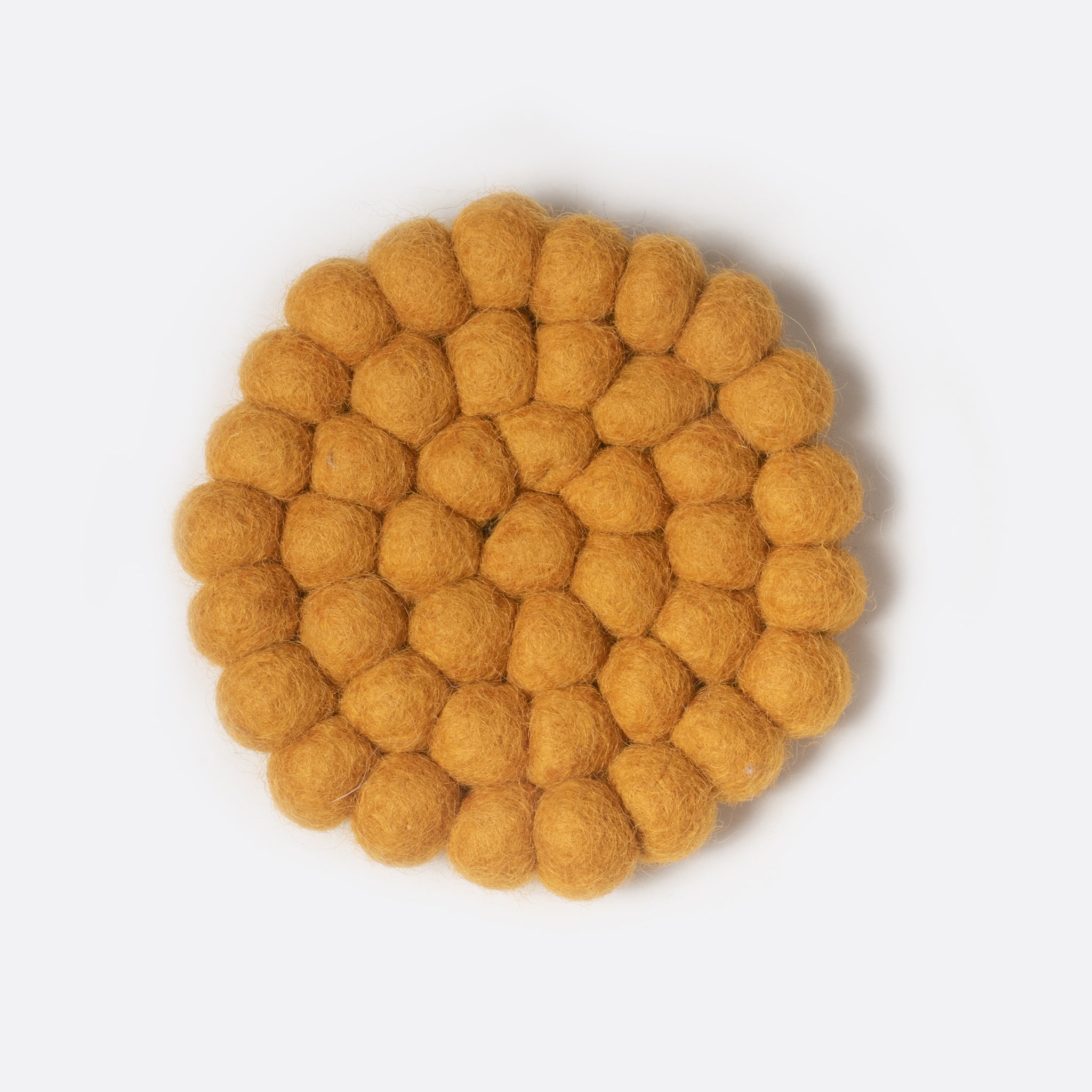 Round small felt coaster which is made from little felt balls. The color is yellow mustard.