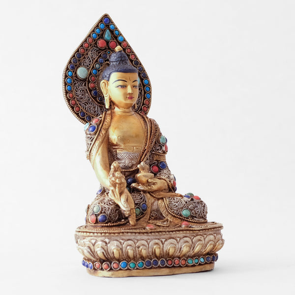 Bhaisajyaguru statue, body from copper, lost wax casting, decorated with fine filigree, gold and silver plated, set with turquoise, coral and lapis lazuli. The face is set in gold. Handmade in Nepal
