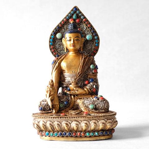 Bhaisajyaguru statue, body from copper, lost wax casting, decorated with fine filigree, gold and silver plated, set with turquoise, coral and lapis lazuli. The face is set in gold. Handmade in Nepal