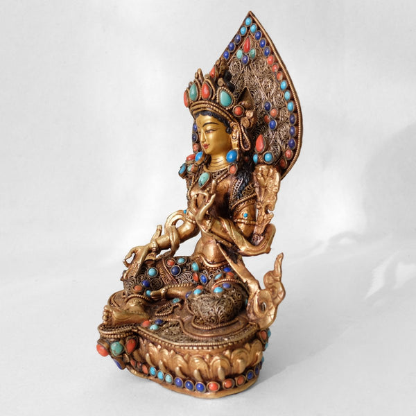Green Tara statue, body from copper, lost wax casting, decorated with fine filigree, gold and silver plated, set with turquoise, coral and lapis lazuli. The face is set in gold. Handmade in Nepal.