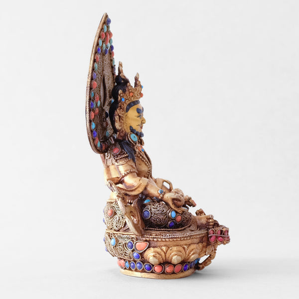 Jambhala statue, body from copper, lost wax casting, decorated with fine filigree, gold and silver plated, set with turquoise, coral and lapis lazuli. The face is set in gold. Handmade in Nepal