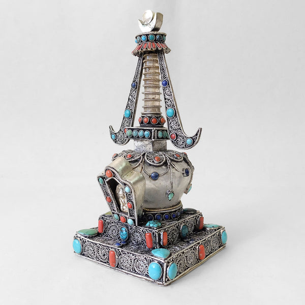 Small stupa made of crystal and copper. Decorated with filigree. Silver plated. Set with coral, lapis lazuli and turquoise. Handmade in Nepal