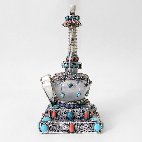 Sideview. Small stupa made of crystal and copper. Decorated with filigree. Silver plated. Set with coral, lapis lazuli and turquoise.