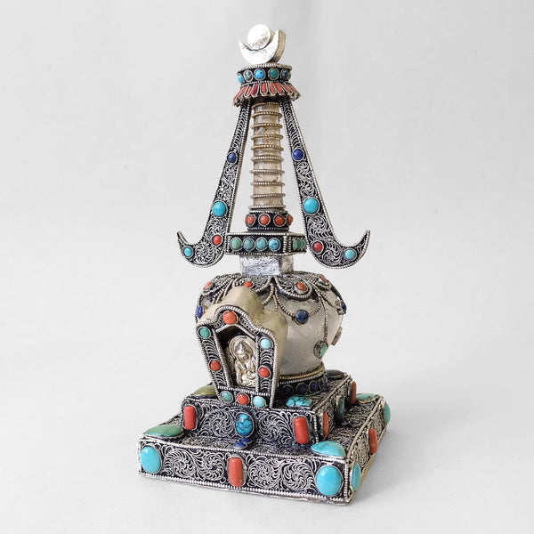 Front view, small stupa made of crystal and copper. Decorated with filigree. Silver plated. Set with coral, lapis lazuli and turquoise. Handmade in Nepal